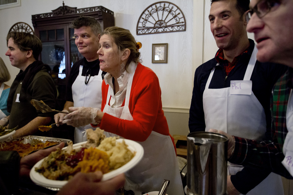 Volunteers, from left, John Monahan, Michael Quint, Marlies Heitmann, Phil Allard and Perry St. Louis serve a Thanksgiving meal at the Portland Club during last year's Wayside Food Programs’ annual community dinner.