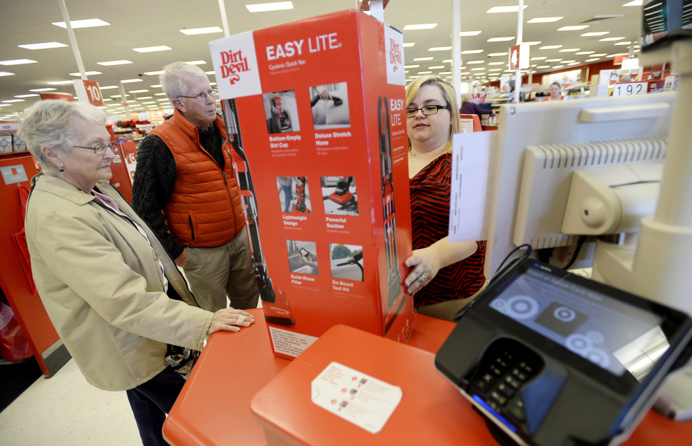 Cashier Danielle Johnson checks out Lorraine Libby of Scarborough and Gordon Smith of Cape Elizabeth at Target, which has taken an extra step in payment security by offering cards with microchips and requiring cardholders to enter a PIN.