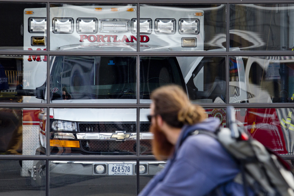 A bicyclist rides past the ambulance at Munjoy Station on Friday, when the ambulance was back in service from 8 a.m. to 8 p.m.