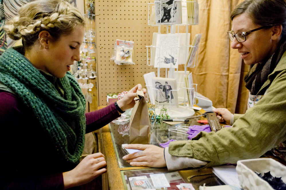 Emily Stout of Worcester, Mass., left, finishes a transaction with Diane Toepfer at Ferdinand in Portland on Small Business Saturday, a day created by American Express six years ago.