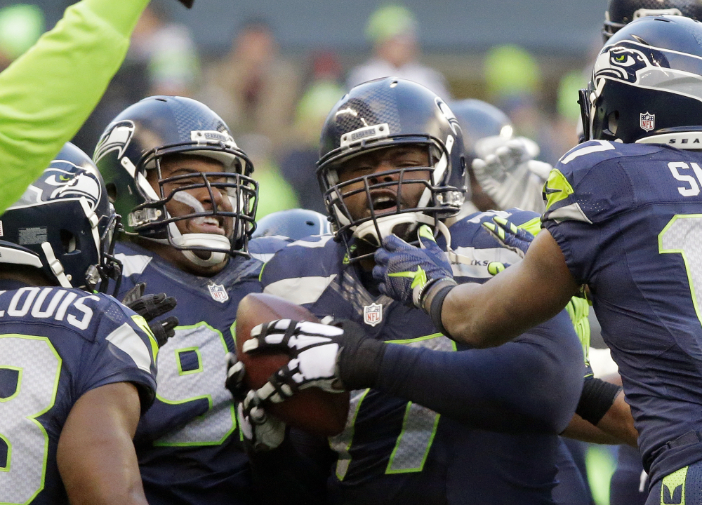 Seattle’s Ahtyba Rubin, center, is congratulated after his interception in the second half of the Seahawks’ 39-30 win over the Steelers on Sunday in Seattle.
