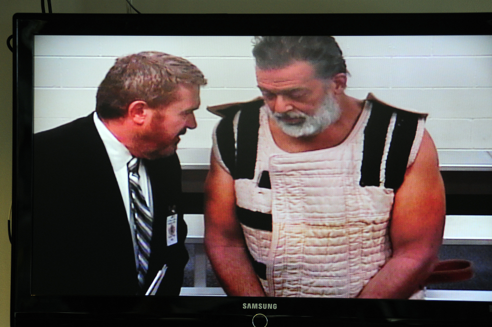 Planned Parenthood shooting suspect Robert Lewis Dear, assisted by public defender Daniel King, appears Monday via video before Judge Gilbert Martinez in Colorado Springs, Colo. When asked if he understood his rights, Dear replied, “No questions.”