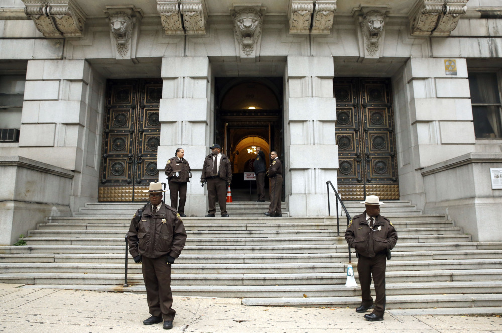 Members of the Baltimore City Sheriff’s Office stand outside Clarence M. Mitchell Jr. Courthouse in Baltimore on Monday, after the arrival of William Porter, one of six Baltimore city police officers charged in connection to the death of Freddie Gray.