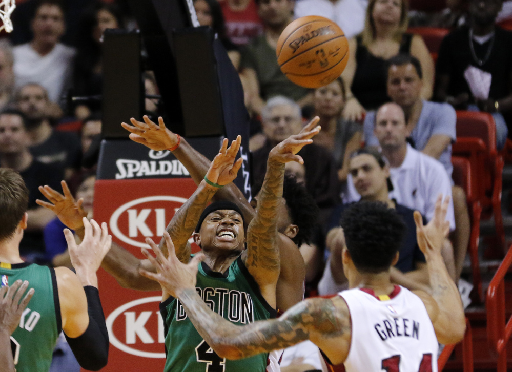 Celtics guard Isaiah Thomas passes from under the basket as Miami Heat guard Gerald Green defends. Thomas scored 16 points in the Celtics’ 105-95 win.