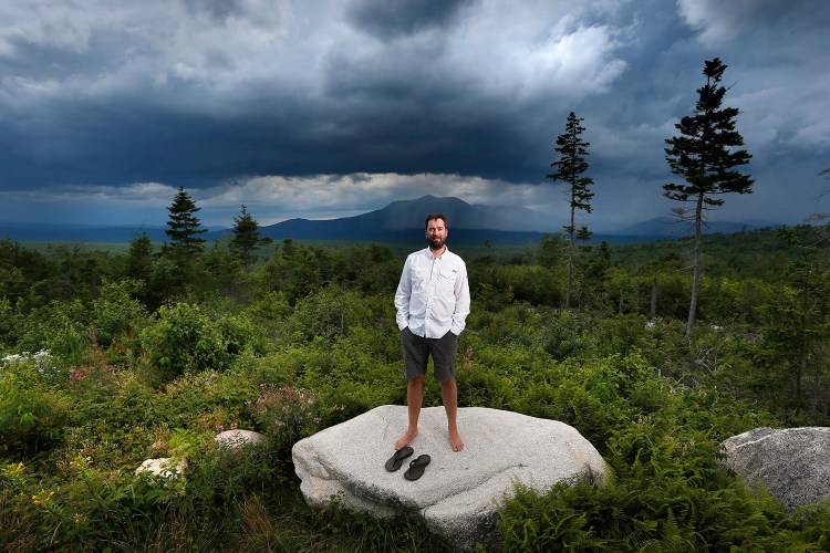 Lucas St. Clair, who is managing a nonprofit foundation set up to promote the creation of a park on about 70,000 acres owned by his mother, Burt's Bees founder Roxanne Quimby, stands on the land proposed for the park in Penobscot County, Maine. Mount Katahdin, the state's highest peak, can be seen in the background as a rainstorm passes through Baxter State Park. 