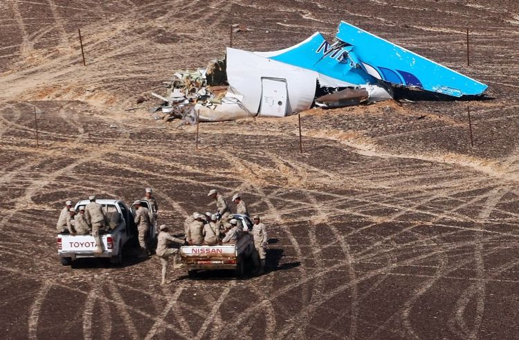 Egyptian military personnel approach the Metrojet plane's tail at the wreckage site in Hassana, Egypt, on Sunday. Russian Ministry for Emergency Situations via AP