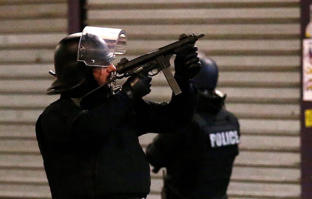 A police officer points his weapon during Wednesday morning's operation outside Paris.
The Associated Press