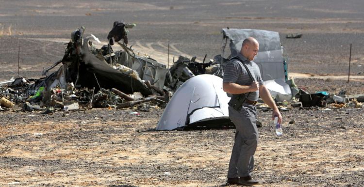 A Russian investigator walks near wreckage a day after a passenger jet bound for St. Petersburg, Russia, crashed in Hassana, Egypt. The Russian passenger plane that crashed in Egypt was brought down by a homemade bomb placed on board in a "terrorist" act, the head of Russia's FSB security service told President Vladimir Putin on Tuesday. The Associated Press