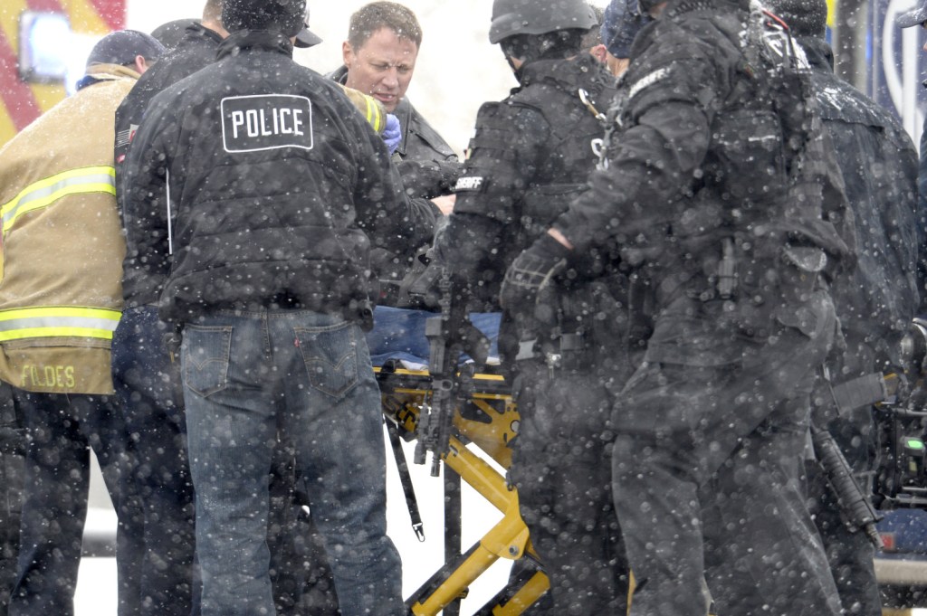 Emergency workers transport an injured officer near the Planned Parenthood clinic in Colorado Springs, Colo., after a gunman opened fire at the clinic on Friday, wounding multiple people.
Andy Cross/The Denver Post via AP
