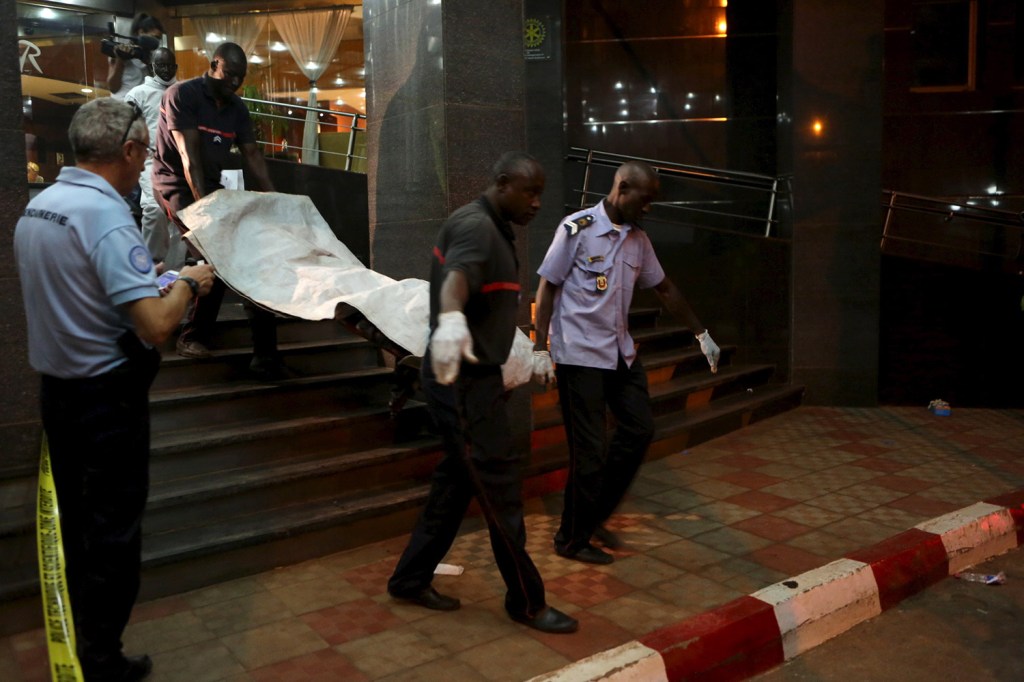 Malian officials carry a body outside the Radisson hotel after gunmen stormed the building in Bamako, Mali, on Friday.