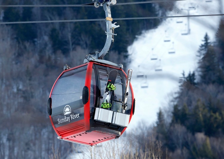 A snowboarder and skier ride the Chondola ski lift at Sunday River in Newry in this March photo. Sunday River is already open seven days a week for the season. An Oct. 19 opening earlier this fall was its third earliest opening in the resort's 56-year history. The Associated Press
