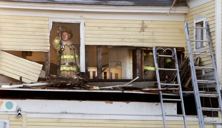 A firefighter checks for hot spots on the second floor of The Yellow House in Kennebunk on Friday. A fire broke out early Friday morning in the building that houses The Sugar Shack, PJ's Unique Peek and Ryan's Corner House, an Irish pub. Gregory Rec/Staff Photographer