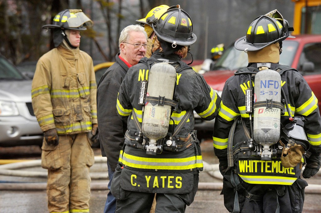 Ovide Corbiel, the owner of Ovide's Used Cars Inc., talks with firefighters at his business, which was destroyed by a fire Thursday.
John Ewing/Staff Photographer