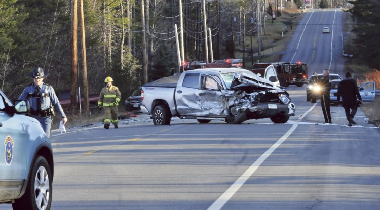 Police and firefighters investigate the scene of a fatal two-vehicle accident on Route 27 in Sidney on Sunday afternoon. This pickup truck and a vehicle that rolled over in a nearby ditch were involved. Bystanders removed an injured boy from the car before it erupted in flames, with a person inside.