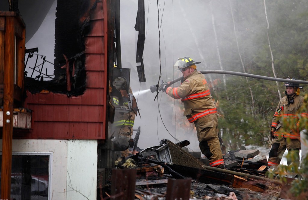 A firefighter sprays water onto the house that was destroyed by fire Wednesday in Lebanon.
Joel Page/Staff Photographer