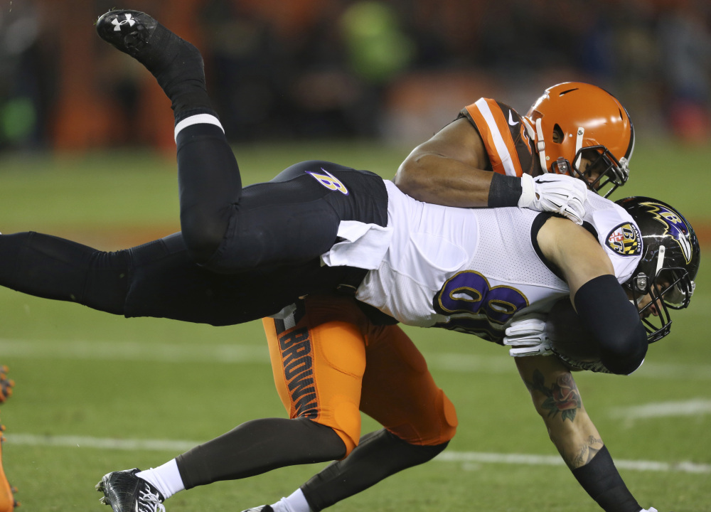 Ravens tight end Crockett Gillmore is tackled by Browns linebacker Craig Robertson in the first half Monday in Cleveland.