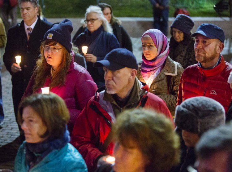 People gather in Monument Square in Portland on Tuesday for a candlelight vigil in memory of those killed in the Colorado Springs Planned Parenthood shooting.