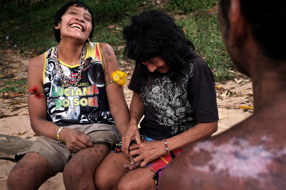 Wirohoa, right, flirts with his wife, Ximirapi, in the indigenous village of Tiracambu, Brazil, last August. Until recently, Wirahoa, who belongs to the Awá tribe, lived as a nomadic hunter/gatherer in the forest with his mother and aunt.