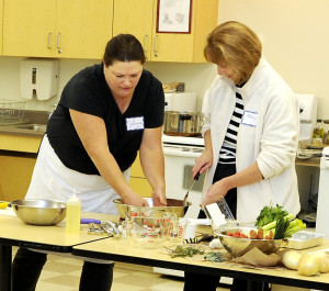Mary Murphy preps ingredients for an apple crisp in the Comforting Foods class taught by JoAnne Wood, left. Gordon Chibroski photo