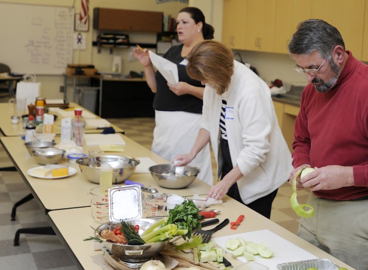 Adult education students Mary Murphy and Pete Blunda, both from Gorham, help prep the ingredients for an apple crisp recipe in a "comfort foods" cooking class taught by JoAnne Wood at Gorham Middle School. 