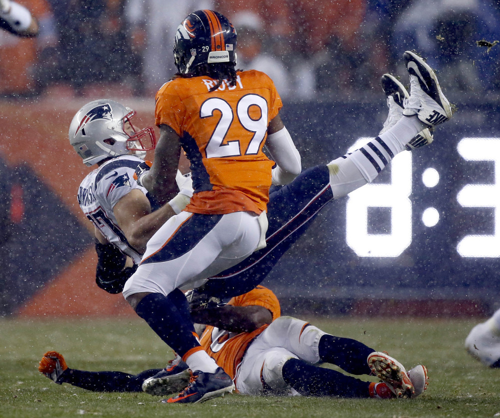 Rob Gronkowski is upended by Denver safeties Darian Stewart, on ground, and Bradley Roby. Later in Sunday night’s game, Gronkowski was carted off the field.
