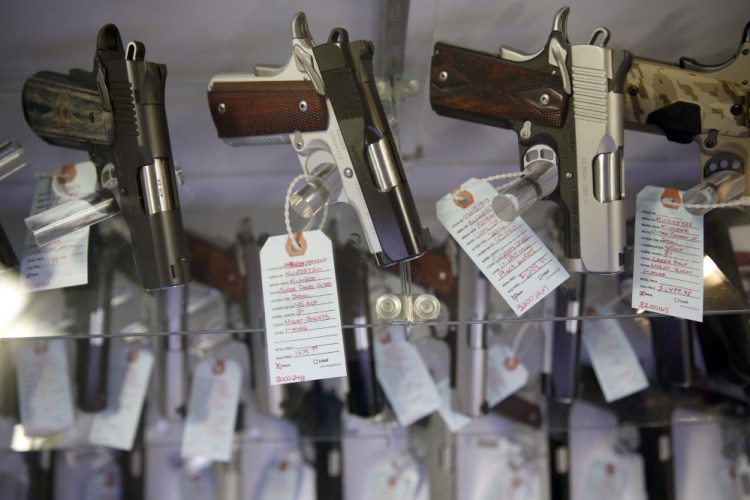 Handguns sit in a glass display case in Bridgeton, Mo., in November 2015.