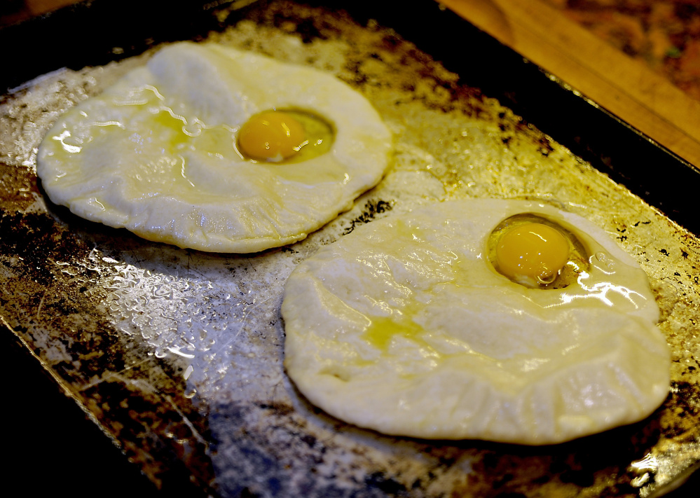 The flatbread is partially baked, then topped with an egg.