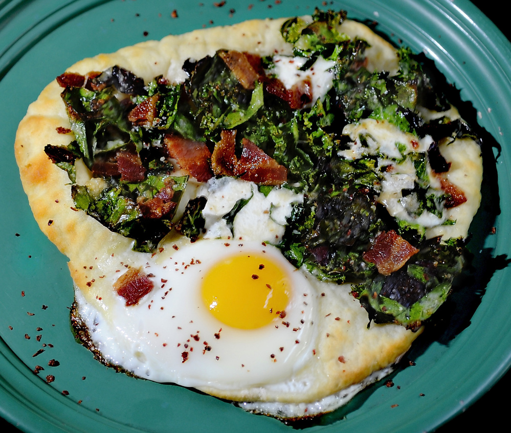 A two-ingredient flatbread forms the base for an Egg-in-the-Hole Pizza with bacon, greens and pepper. Gordon Chibroski/Staff Photographer