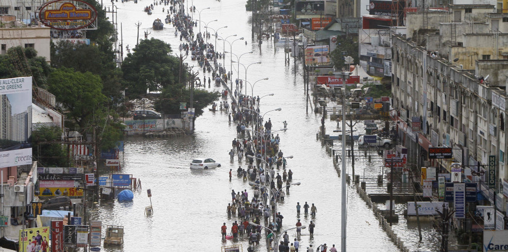 People walk through a flooded street Thursday in Chennai, the capital of the southern Indian state of Tamil Nadu.