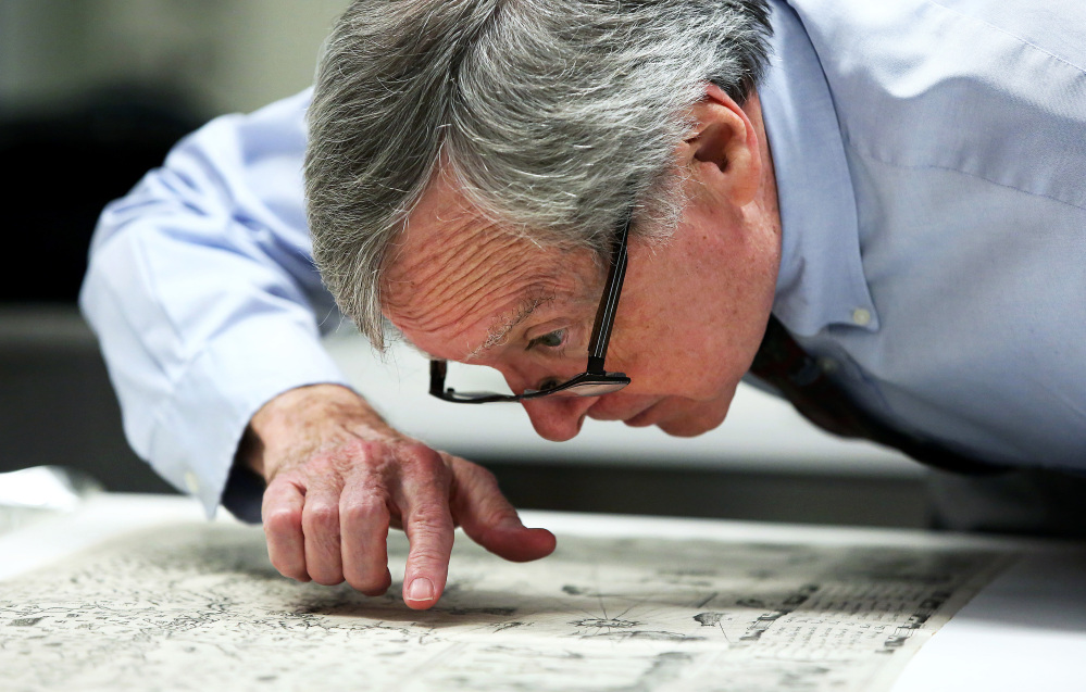 Boston Public Library curator of maps Ronald Grim, who helped reclaim a centuries-old map that was stolen from the library, examines the map Thursday in Boston.