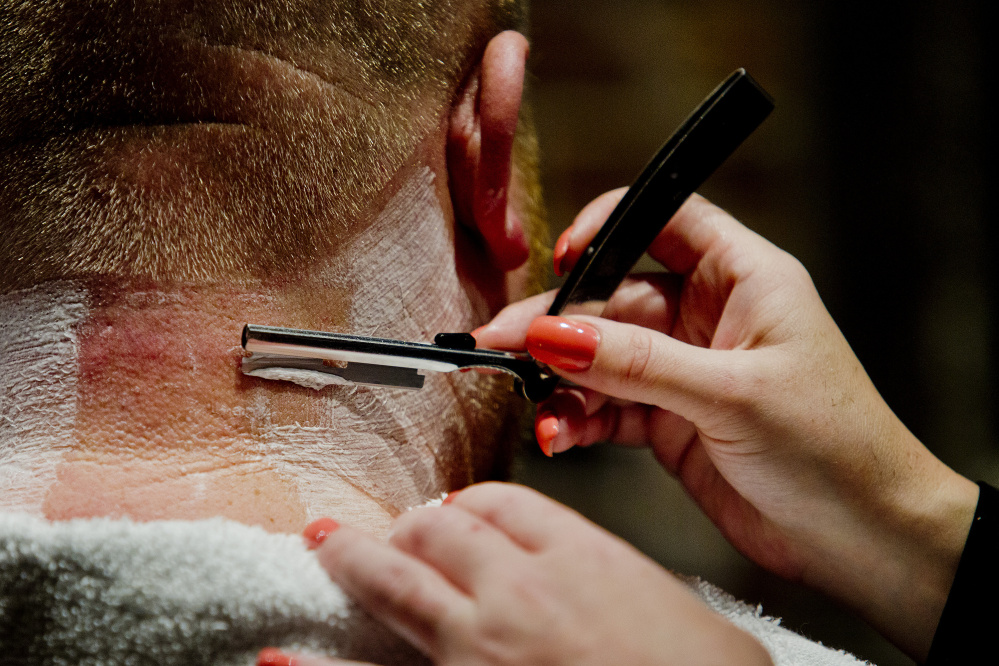 Men get a straight razor shave after their haircut at the Mensroom. Gabe Souza/Staff Photographer