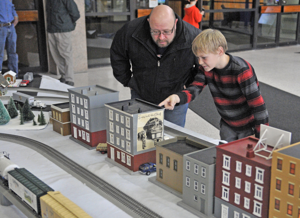 China residents Sean Boynton, left, and son Sam, 11, look at the model railroad displays Friday in the atrium of the Cultural Building, which houses the Maine State Museum, in Augusta.