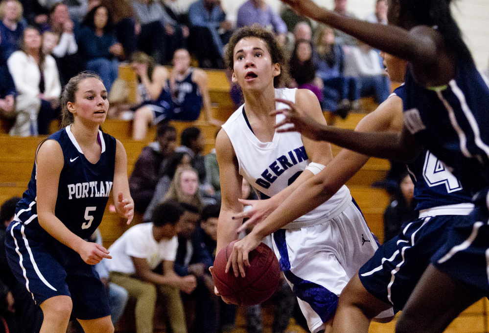 Abby Ramirez of Deering has her focus on the basket while driving between Taylor Sargent, left, and Nettie Walsh of Portland for a layup in the first half at Deering High. Deering took an 18-1 lead and never was threatened.