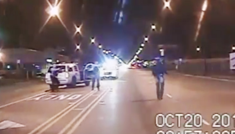 In this Oct. 20, 2014 frame from dash-cam video, Laquan McDonald, right, walks down the street moments before being shot by police officer Jason Van Dyke in Chicago.