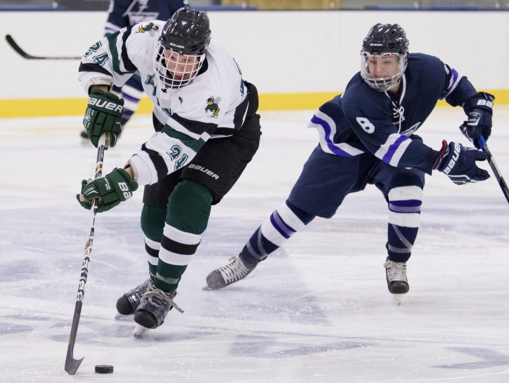 Leavitt's Lucas Perry skates up ice with Portland/Deering's Giovanni Ruotolo in pursuit during Saturday's ame at the Norway Savings Bank Arena in Auburn Photo by Gabe Souza/Staff Photographer