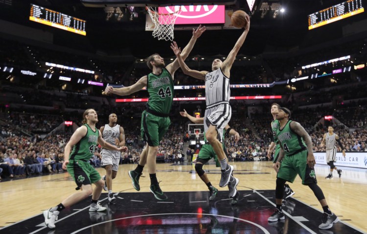 San Antonio Spurs guard Manu Ginobili (20) drives to the basket against Boston Celtics center Tyler Zeller (44) during the first half of Saturay's game in San Antonio.