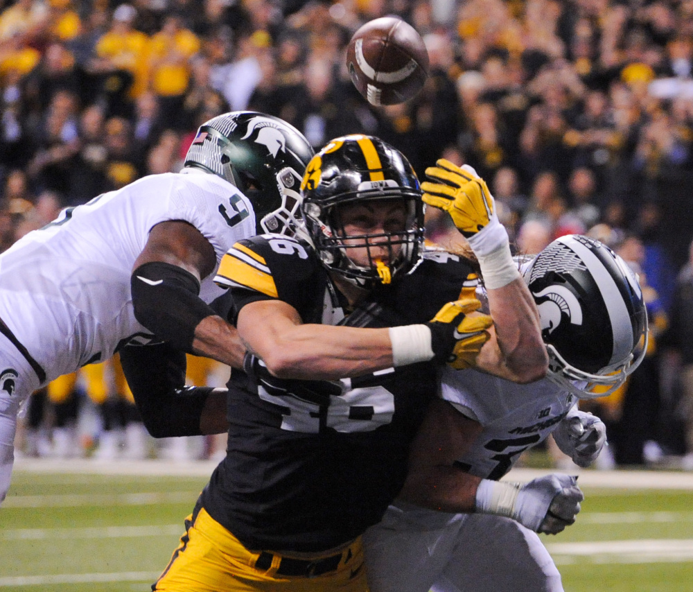 George Kittle of Iowa is unable to catch a pass in the end zone Saturday night as Montae Nicholson, left, and Riley Bullough of Michigan State defend in the second quarter of Michigan State’s 13-10 victory in the Big Ten championship game at Indianapolis.