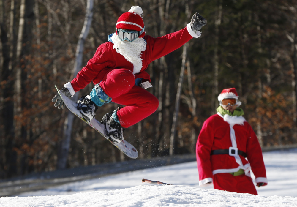 Snowboarder Jaden Bao, 12, of South Portland, catches some air while participating in Santa Sunday, the 16th annual charity fundraising event at the Sunday River ski resort, on Sunday in Newry.