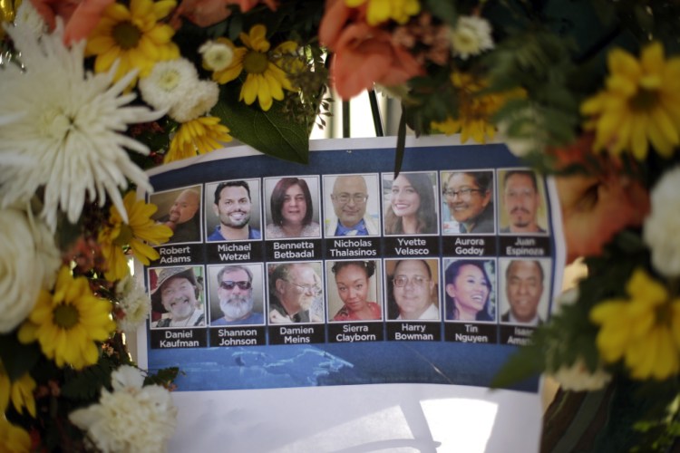 Pictures of shooting victims are displayed at a makeshift memorial site in San Bernardino, Calif. Workers returned Monday to the offices where a food inspector and his wife on Dec. 2 opened fire on a gathering of his co-workers, killing 14 people and wounding 21.