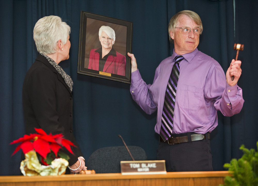 Newly inaugurated Mayor Tom Blake presents outgoing Mayor Linda Cohen with a gavel and a framed portrait after succeeding her at Monday evening’s inaugural ceremony at City Hall.