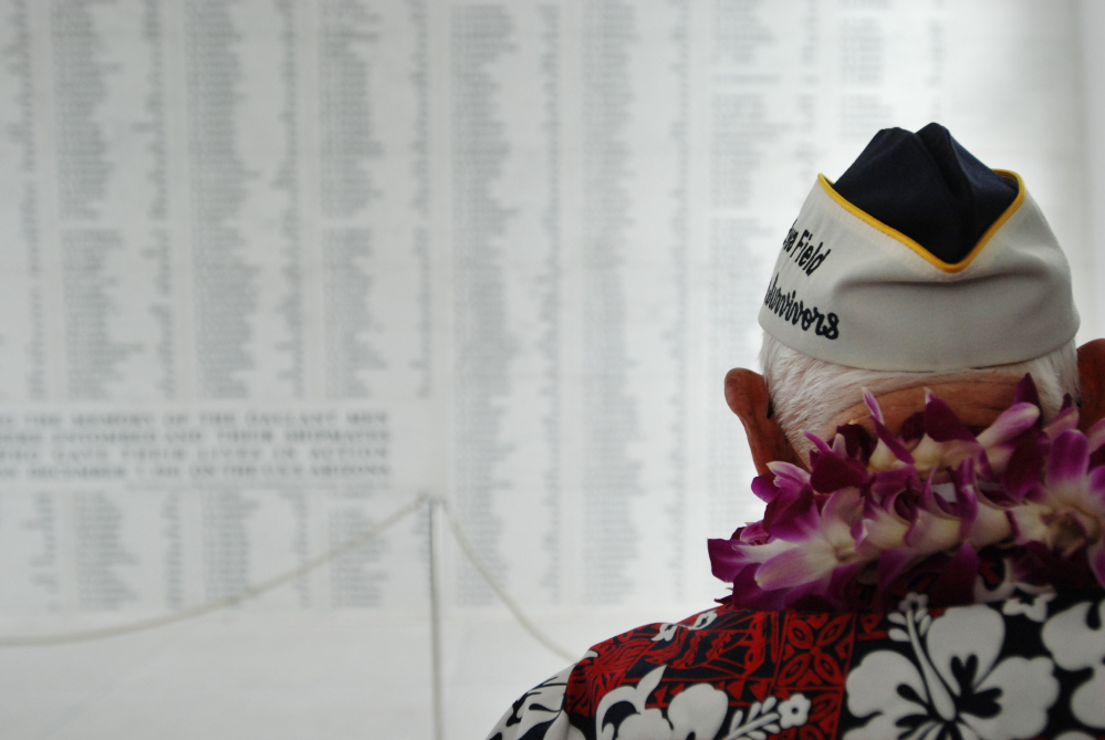 Pearl Harbor survivor John Hughes views a wall engraved with the names of USS Arizona sailors and Marines killed in the Japanese attack on Pearl Harbor.