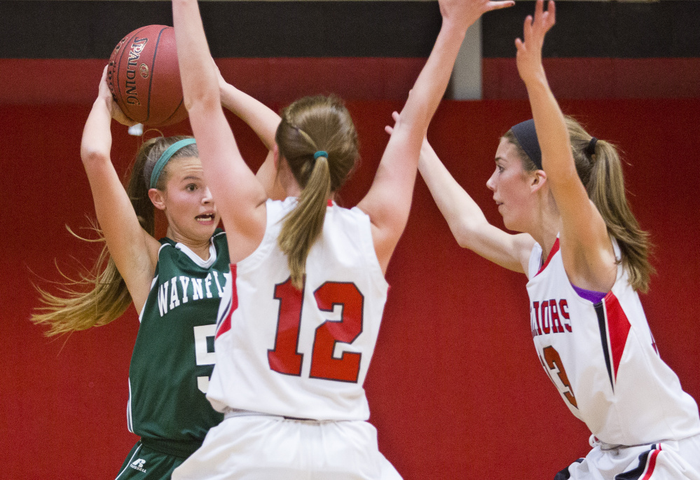 Waynflete guard Izzy Burdick is pressured by Wells guard Ally O’Brien and forward Megan Schneider during the Warriors’ 47-28 win Monday in Wells.