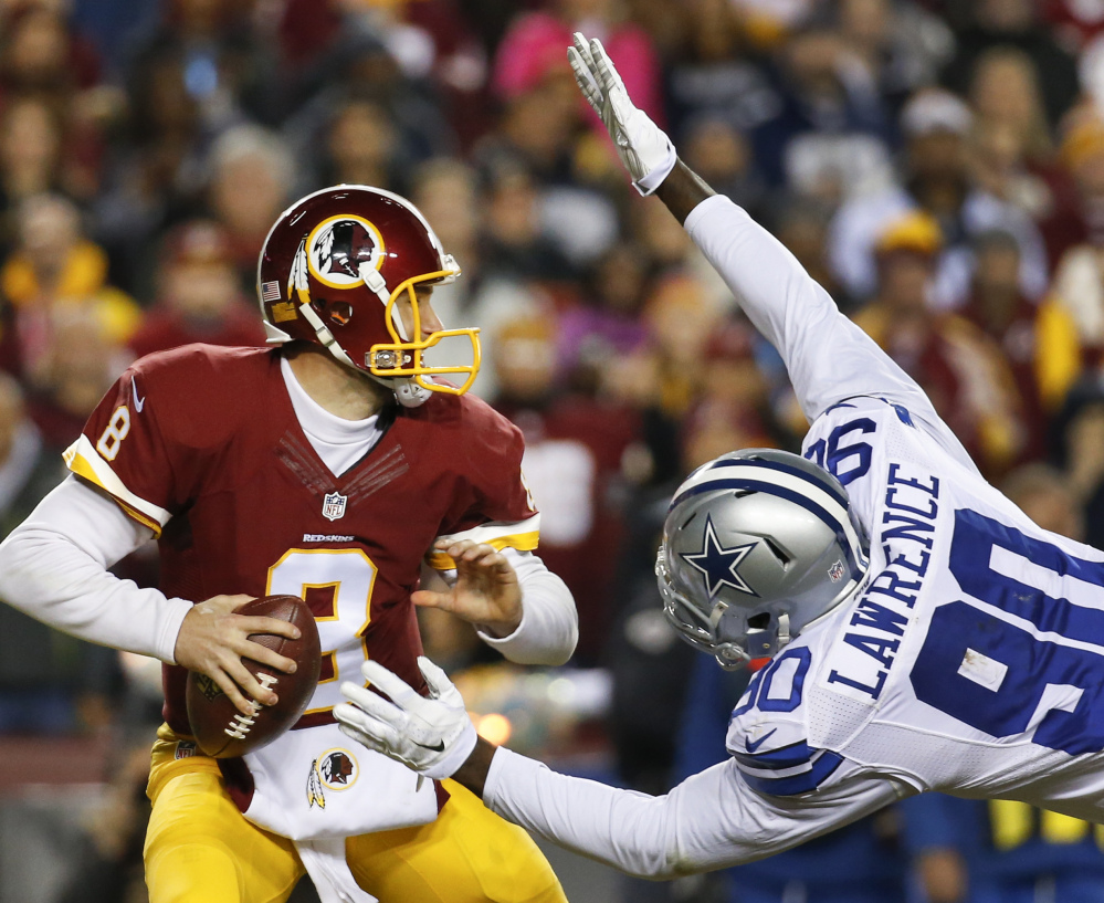 Cowboys defensive end Demarcus Lawrence leaps at Washington quarterback Kirk Cousins for a sack during the first half of their game Monday in Landover, Maryland.