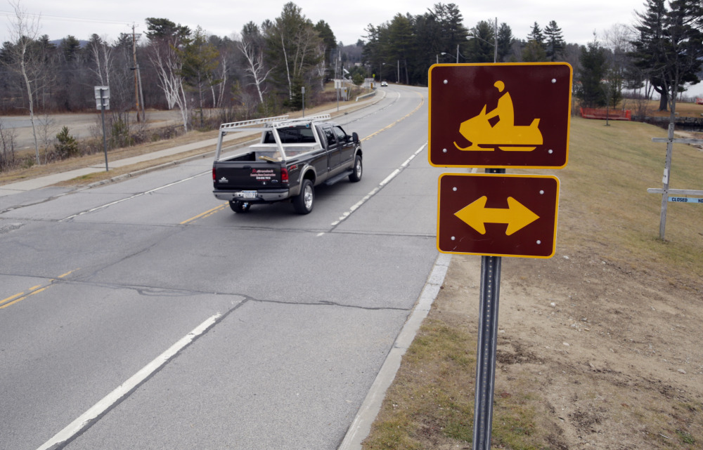 A snowmobile crossing sign is seen along snowless Route 30 in Speculator, N.Y., on Tuesday.
