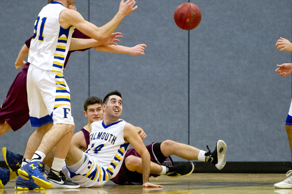 Justin Guerette and Thomas Coyne of Falmouth look on from the floor after as their teammates fight for possession of the ball before it bounces out of bounds. Gabe Souza/Staff Photographer