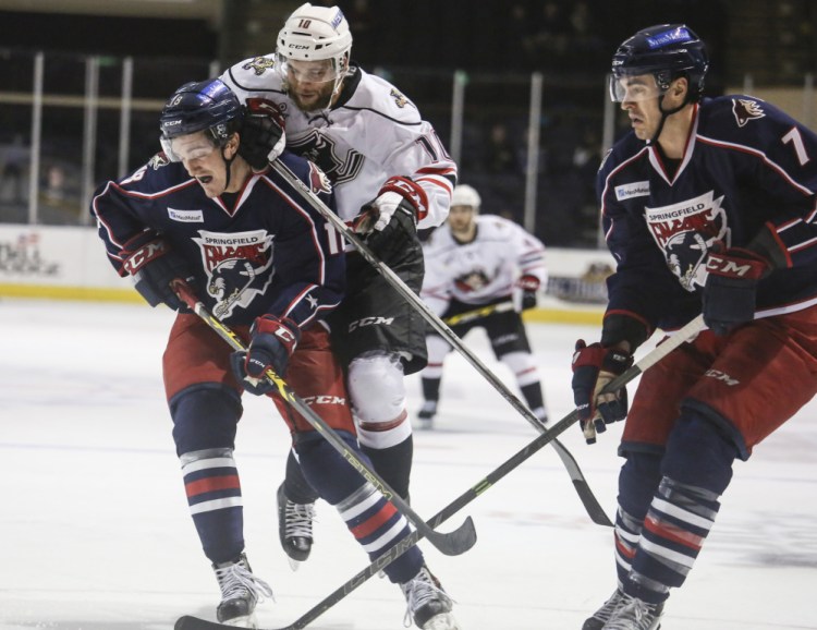 Pirates center Rob Schremp dives atop Springfield Falcons left wing Dan O’Donoghue while defender Steven Delisle watches the goal at the Cross Insurance Arena in Portland on Wednesday.