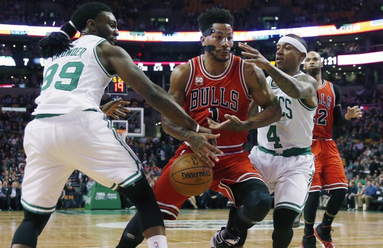 The Bulls’ Derrick Rose loses control of the ball as he tries to drive between the Celtics’ Jae Crowder and Isaiah Thomas in the first quarter of the Celtics’ win on Wednesday night in Boston. Thomas led the Celtics’ scoring with 20 points.