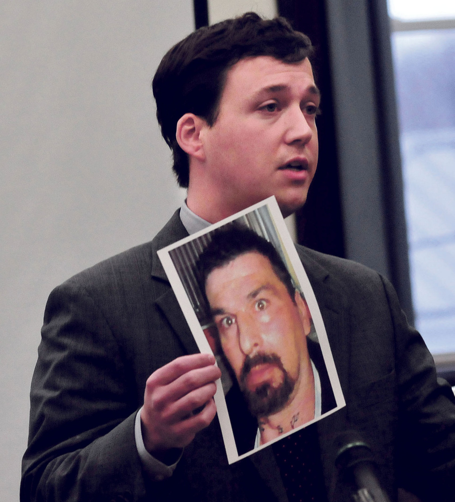 Defense attorney Caleb Gannon holds a photograph of Ricky Cole, who was killed in 2013, during the first day of trial of Jason Cote, of Palmyra, on Thursday in Somerset County Superior Court in Skowhegan.