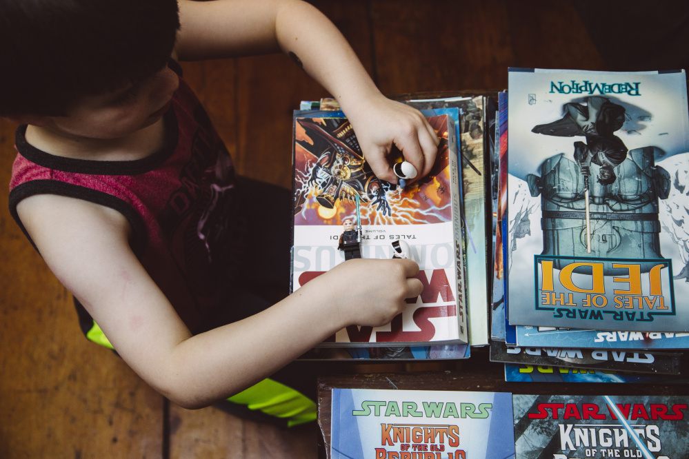 SOUTH PORTLAND, ME - DECEMBER 2: Abraham Irvine, (cq)  5, plays with Star Wars legos atop a collection of Star Wars graphic novels at their home in South Portland, ME on Wednesday, December 2, 2015. (Photo by Whitney Hayward/Staff Photographer)