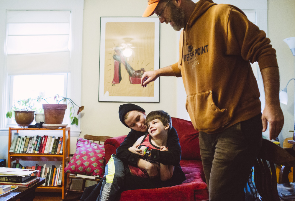 Emma Irvine, 14, holds her brother Abraham Irvine 5, with their father Alex Irvine at their home in South Portland. Irvine is a science fiction writer, along with a Star Wars fan, and he’s passed down a love for both to his three children.